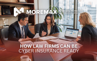 Law firm leadership team reviewing cybersecurity, compliance, and business continuity documents in a modern conference room with laptops, printed checklists, and natural daylight streaming through large windows.
